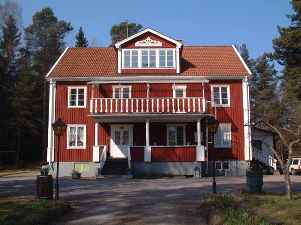 Sunnanskogs röda huvudbyggnad omgiven av skog